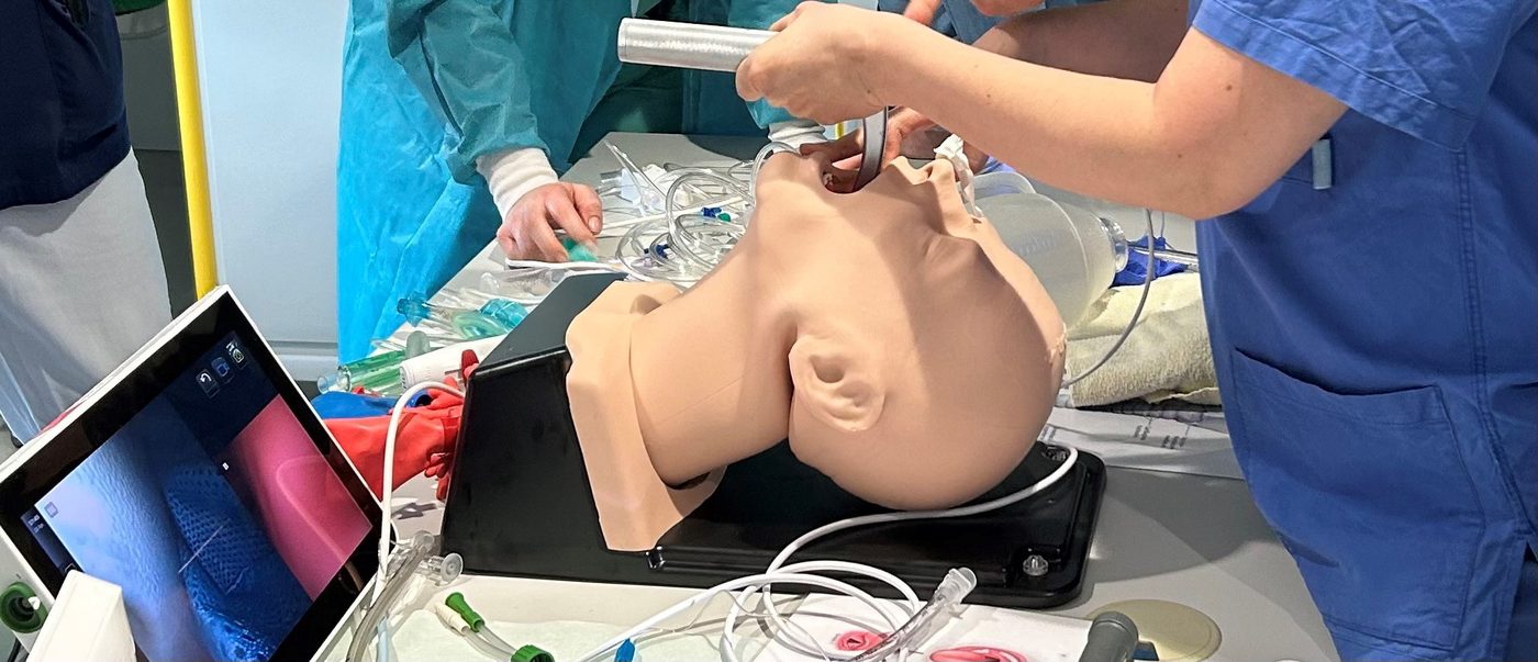 Teilnehmende üben die Intubation am Atemwegsmodell, ein Videolaryngoskop-Monitor im Vordergrund
